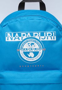 Zaino di tessuto blu con un logo circolare che presenta il testo "NAPAPIJRI", "PROGRAMMA DI RICERCA ANTARTICA" e accenti geografici in bianco e arancione.