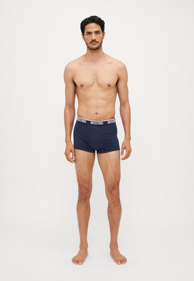 Navyblauwe boxershorts voor heren met een zwarte tailleband waarop het Moschino-logo staat, gemaakt van een gladde, rekbare stof.