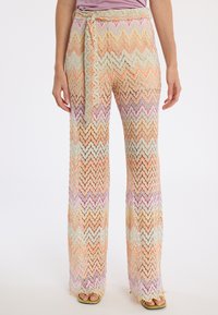 Spitzenhose mit Zickzack-Muster in sanften Farbnuancen von Orange, Lavendel und Minze, mit Bindeband in der Taille und weitem Bein. Strukturierter Stoff.