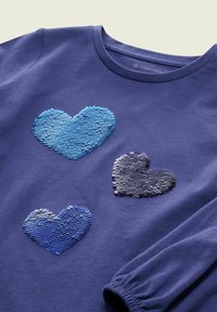 Marineblauwe sweatshirt met drie met pailletten versierde harten in verschillende tinten blauw en marine. Zachte stof, ronde halslijn en geplooid mouwdetail.