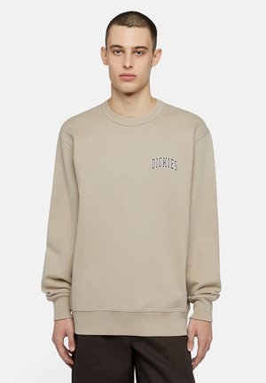 Sudadera beige hecha de una mezcla de algodón, con cuello redondo acanalado, mangas largas y un logo bordado en el lado izquierdo del pecho.