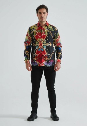 Chemise à manches longues ornée d'un imprimé multicolore de chaînes et de papillons sur fond noir. Elle comprend un col et une fermeture à boutons.