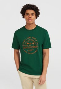Mørkegrøn bomulds t-shirt med cirkulært orange grafisk tekst. Korte ærmer og rund hals design. Casual pasform med minimale detaljer.