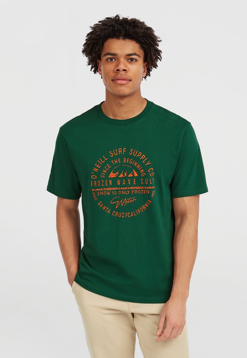 Mørkegrøn bomulds t-shirt med cirkulært orange grafisk tekst. Korte ærmer og rund hals design. Casual pasform med minimale detaljer.