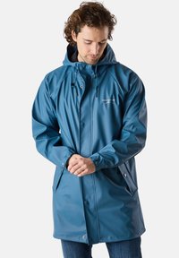 Vattentät blå regnkappa med huva, tryckknappar och justerbara snoddar. Tillverkad av glatt, glänsande material. Har sidofickor.