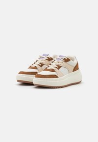 Brązowe zamszowe i kremowe syntetyczne sneakersy z białą teksturowaną podeszwą środkową, purpurowymi akcentami i tradycyjnymi sznurowadłami, o masywnej konstrukcji.