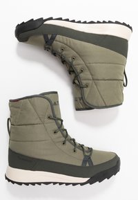 Grønne isolerede støvler med quiltet overdel, snøre-design og kontrasterende sort gummisål. Har "CLIMAPROOF" branding på siden.