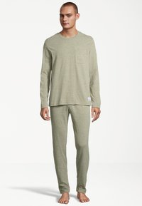 Soft, lightweight green pajamas featuring a long-sleeve shirt with a pocket and matching snug-fit pants. Fitted design with minimal texture.