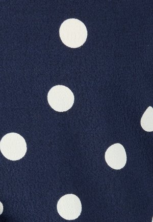 Marineblauer Stoff mit gleichmäßig verteilten großen weißen Polka-Dots, sichtbare strukturierte Webung.