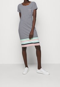 Pasiasta sukienka z krótkim rękawem w granatowo-białym kolorze, z kolorem blokowanym u dołu w różowe, miętowe i granatowe pasy. Kieszonka na piersi.