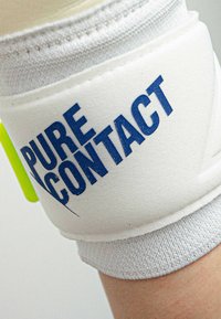 Supporto per polso in tessuto bianco con la scritta "PURE CONTACT" stampata in lettere blu in grassetto; presenta un design senza cuciture e un polsino texturizzato alla base.