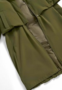 Lungo cappotto verde oliva con zip frontale, bottoni a pressione, tasche laterali e dettaglio del colletto imbottito.