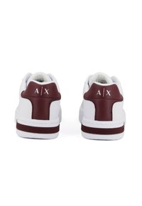 Sneakers bianchi con accenti maroon sul tallone e logo "A|X" sul retro, mostrati da dietro su uno sfondo bianco.