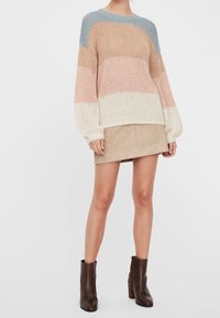 Maglione a maglia grossa con strisce orizzontali blu, pesca, crema e beige, abbinato a una gonna in suede beige e stivaletti marroni.