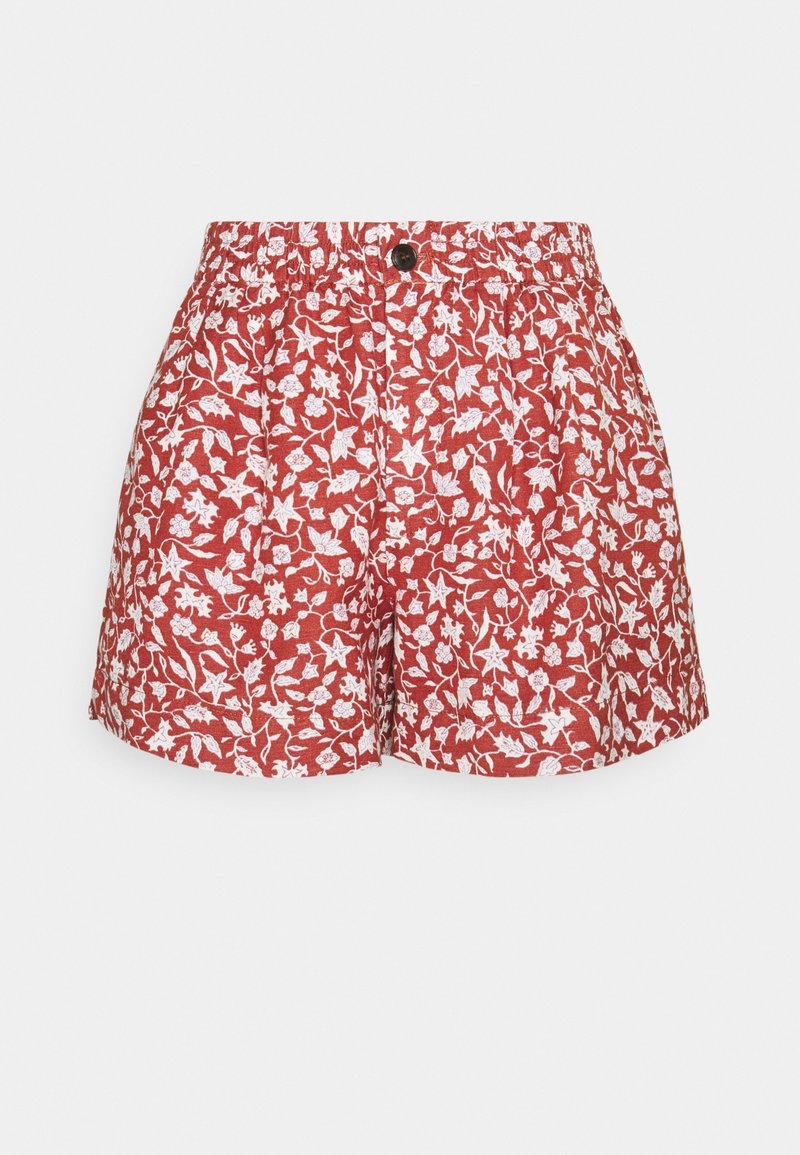 Short rouge à taille élastique avec motif floral blanc en forme de vigne et fermeture par un bouton noir unique à l'avant.