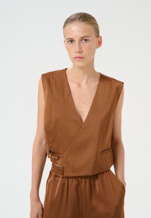 Brun ærmeløs top med dyb V-udskæring, glat satin stof, sidelommer og elastisk talje. Enkelt, moderne design.