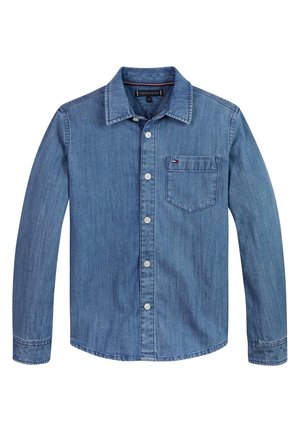 Camisa de mezclilla azul claro de manga larga con cierre de botones, cuello puntiagudo y un bolsillo en el pecho con un pequeño logo de bandera roja, blanca y azul.