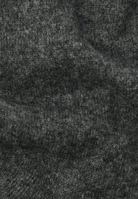 Tejido de punto gris oscuro con una textura suave y peluda, y un sutil patrón de canalé, mostrando pliegues y suaves sombras.