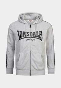 Šedá mikina s kapucňou na zips vyrobená z bavlneného zloženia. Obsahuje výrazné čierne logo "Lonsdale London", predné vrecká a kapucňu so šnúrkou.