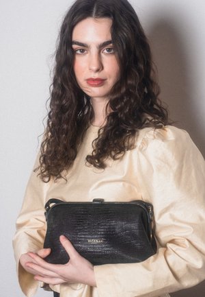 Pochette in pelle nera con texture, chiusura con zip e piccolo manico. Dettaglio logo dorato e forma rettangolare. Design femminile.