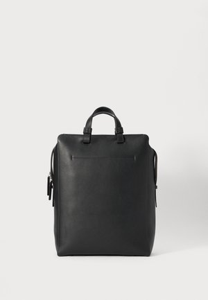 Sac à dos en cuir noir avec deux poignées supérieures, une texture lisse, une forme rectangulaire et une poche latérale zippée pour le rangement.