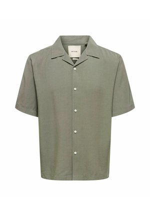 Chemise vert olive à manches courtes, boutonnée, avec col camp, cinq boutons blancs et une étiquette de marque visible à l'intérieur de l'encolure.