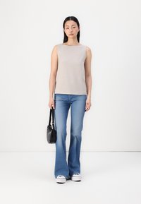 Bēšs bez piedurknēm tops, gaiši džinsu platjaka bikses, melna crossbody soma, baltas kedas. Gluda tekstūra, vienkāršs dizains, monohromatiskas krāsu shēmas.
