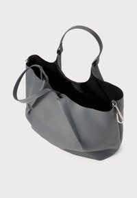 Sac à main en cuir gris avec une surface texturée, un intérieur spacieux et de longues poignées. Dispose d'une fermeture éclair sur un côté pour une fermeture sécurisée.