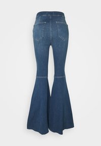 Blå denimlyftade jeans med hög midja, två bakfickor och en sömdetalj ovanför knäet, med en bred benöppning.