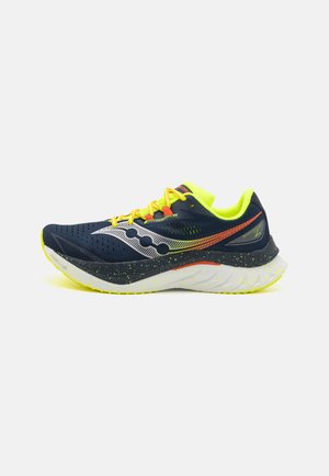 Scarpa da corsa navy con accenti gialli e dettagli riflettenti, dotata di tomaia perforata, suola ammortizzata e intersuola testurizzata e maculata.