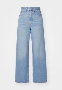 Jean denim bleu clair taille haute à jambes larges avec bouton devant, fermeture éclair et design cinq poches.