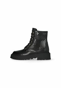 Black ankle boots made of leather and mesh, featuring a perforated design, lace-up front, gold eyelets, and a chunky rubber sole.