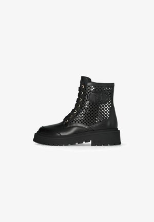 Bottines noires en cuir et maille, avec un design perforé, un laçage à l'avant, des œillets dorés et une semelle en caoutchouc épaisse.
