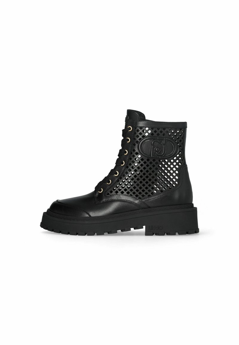 Black ankle boots made of leather and mesh, featuring a perforated design, lace-up front, gold eyelets, and a chunky rubber sole.