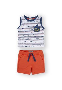 Top sin mangas a rayas en blanco, azul y rojo con gráficos de tiburones y el texto "SALVA EL OCÉANO"; combinado con shorts naranjas con bolsillos.