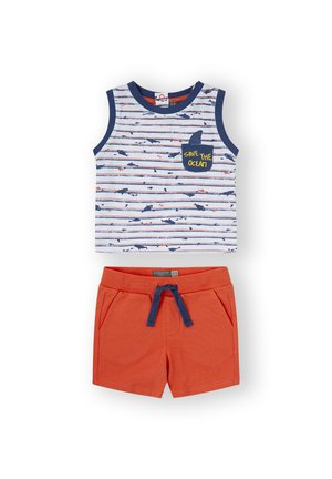 Top sin mangas a rayas en blanco, azul y rojo con gráficos de tiburones y el texto "SALVA EL OCÉANO"; combinado con shorts naranjas con bolsillos.