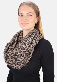 Écharpe infini imprimée léopard en tissu léger, avec un mélange de tons fauves et marron, au toucher doux, portée autour du cou.