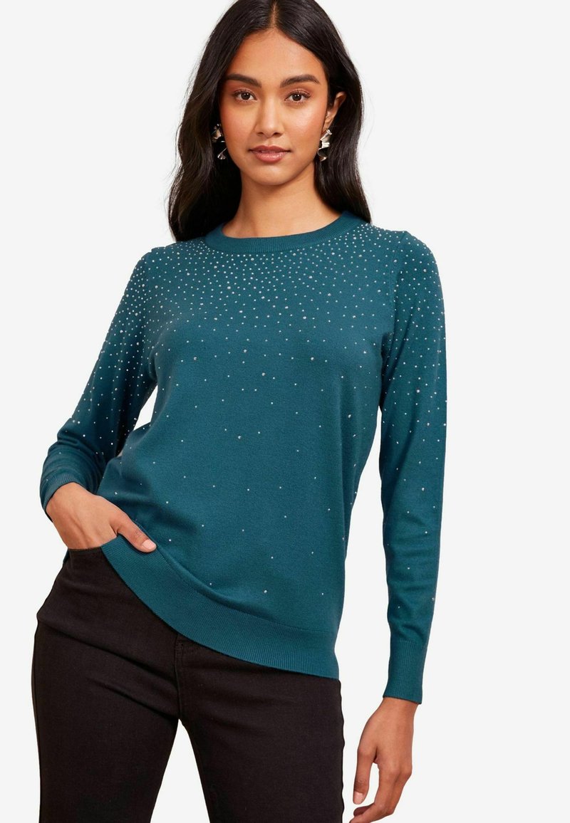 Türkooker, pikkade varrukatega, ümar kaelus ja sädelevate rhinestones'iga kaunistused. Kandmiseks mustad püksid, millel on mugav istuvus.