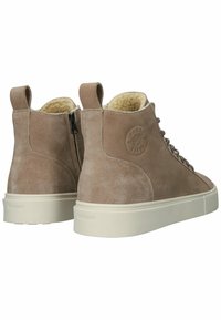 Botas de tobillo de ante marrón con una suela de color claro, interior texturizado y acento de logo. Presentan un diseño con cremallera lateral y cordones.