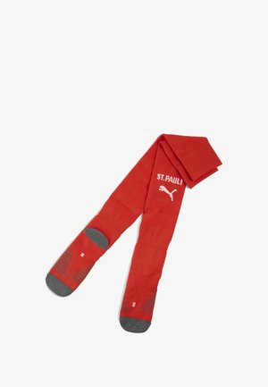 Rote Sportsocken mit weißem "ST. PAULI"-Schriftzug und einem Puma-Logo. Graue, gepolsterte Sohlen mit strukturierten Mustern für besseren Halt.