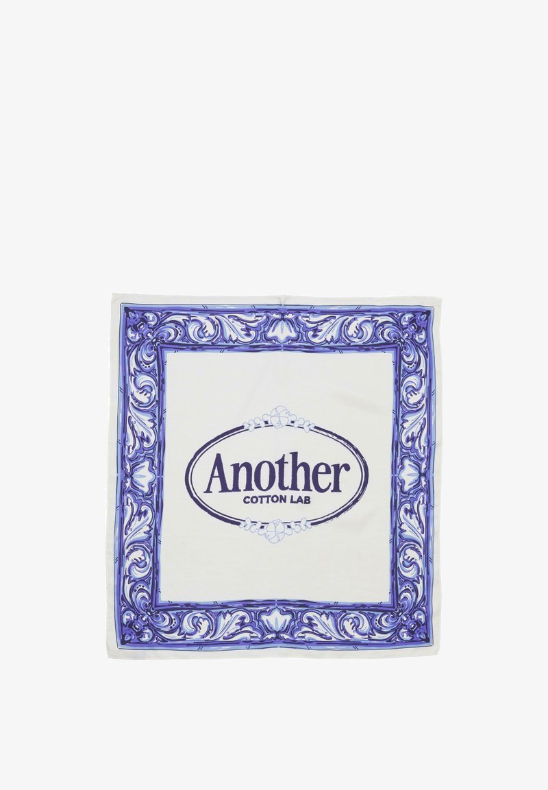 White cotton scarf featuring a blue ornate floral border. Center displays "Another Cotton Lab" in bold purple lettering.