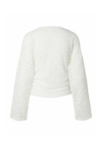 Haut blanc texturé à manches longues avec un motif embossé subtil, encolure ronde et taille légèrement ajustée, montré de dos.