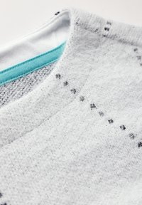 Grijs, zacht-textuur stof met een fuzzy afwerking, met een witte binnenkraag en teal kleurige stiksels. Kleine zwarte stippen zijn zichtbaar.
