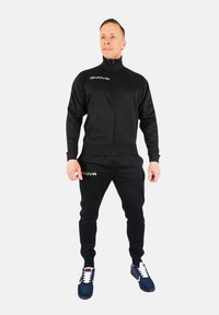 Fekete sportöltöny, puha anyagból, zippzárral ell�átott dzsekivel és passzoló nadrággal. Figyelemre méltó fehér GIVOVA logó a mellkason és a combon.