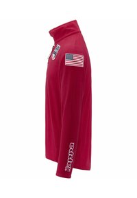 Pullover in pile rosso con colletto alto, chiusura con zip, patch con bandiera americana sulla manica sinistra e logo "Kappa" bianco sulla manica destra.
