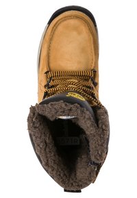 Hnědá kožená bota s robustní černou gumovou podrážkou. Obsahuje měkkou, tmavě hnědou kožešinu uvnitř, černé šňůrky a texturovaný povrch.