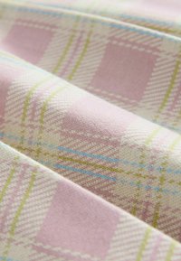 Tissu présentant un motif à carreaux rose avec des accents vert clair et bleu. Le tissu a une texture lisse et un tissage uniforme.