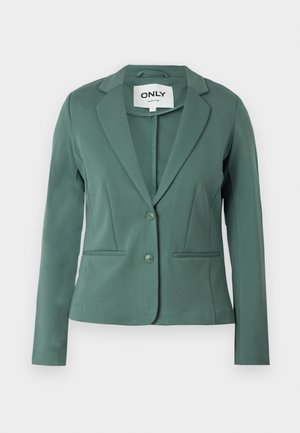 Zielona marynarka wykonana z miękkiego materiału, z kołnierzykiem typu lapel, z zapięciem na jeden guzik oraz dwiema przednimi kieszeniami. Dopasowany krój o czystych liniach.
