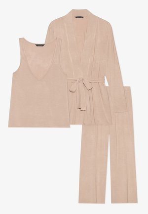 Cet ensemble de détente beige en trois pièces comprend un haut sans manches avec un col en V, un cardigan à nouer à l'avant et un pantalon évasé, le tout en tissu doux et texturé.