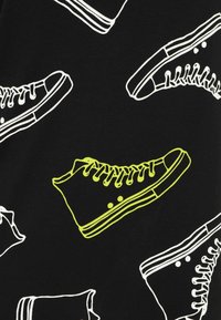 Black fabric featuring a repeated pattern of white and neon green high-top sneakers, displaying laces and sole details.